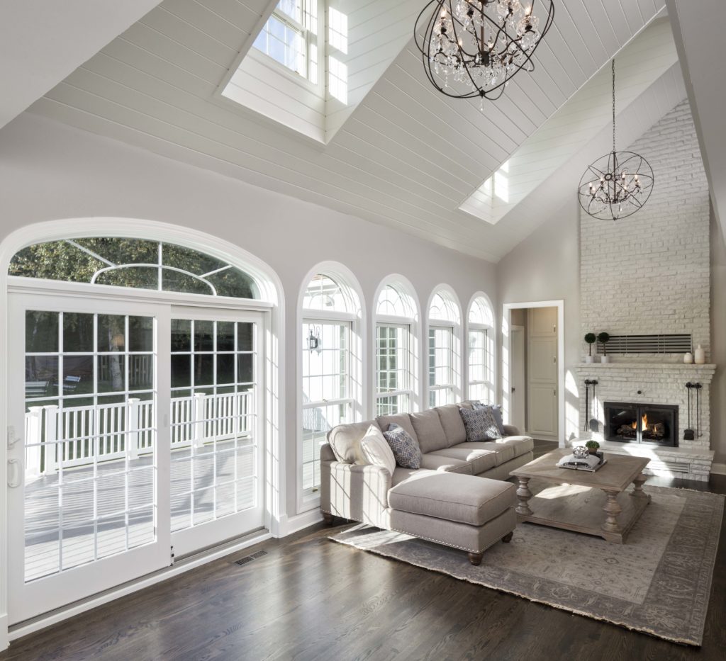Interior living room with white walls and white vaulted ceilings and many windows.