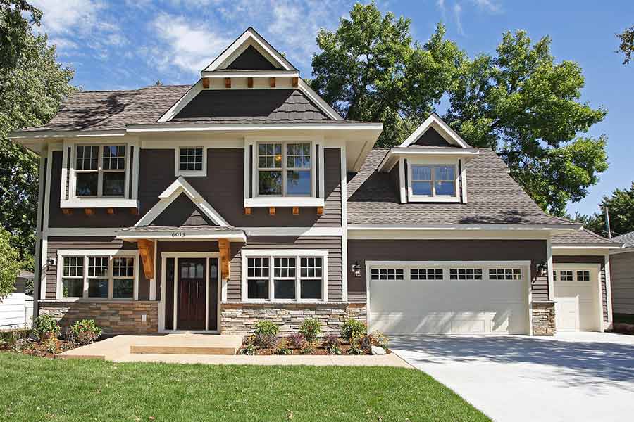 Gray two story home with white trim and stone accents.