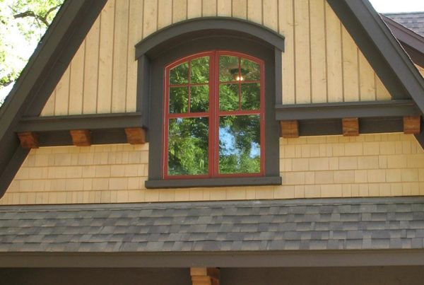 Close up of window on yellow home with red trim.