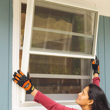 Woman with gloves, installing a window.
