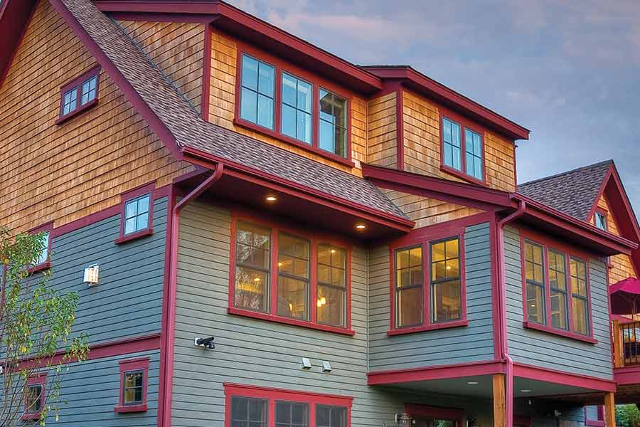 Light green with red trim and cedar shakes two story home.