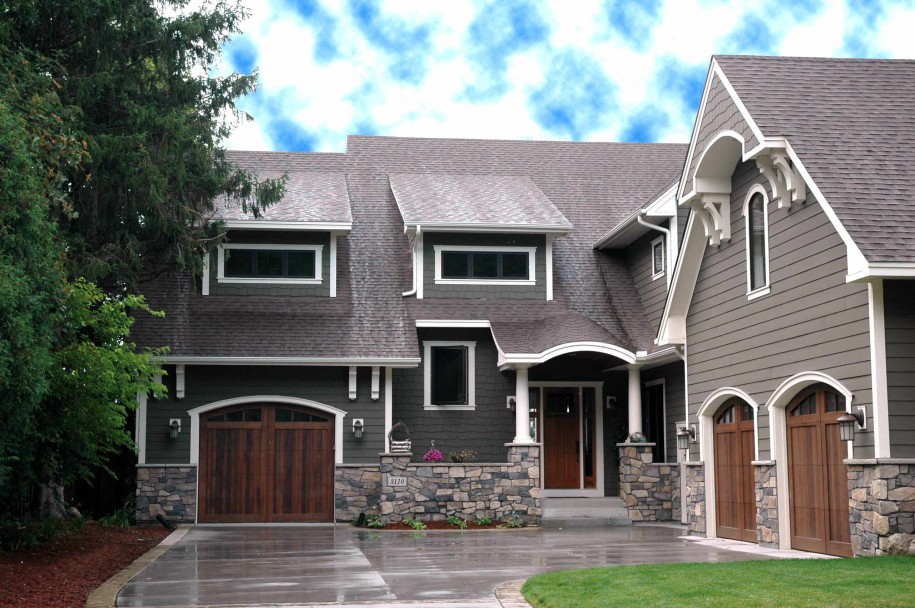 Gray two story home with Hardie plank siding and split garage with stone accents.