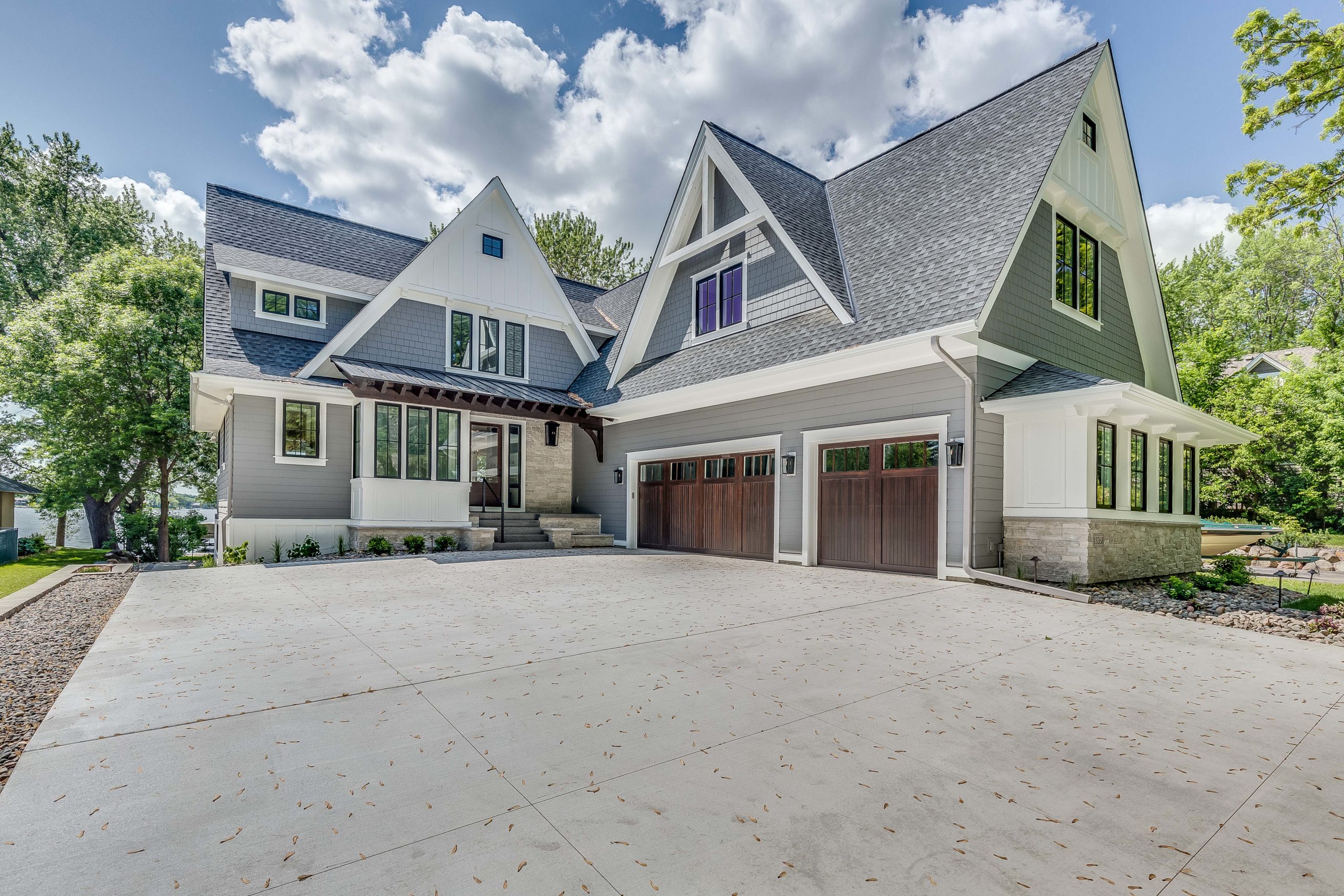 Light gray two story lake home with large gables.