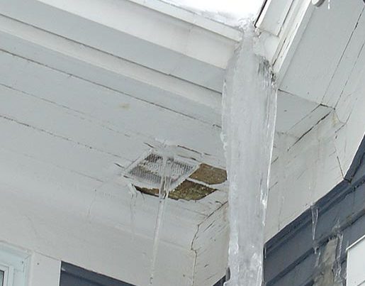 Close up of roof with damage to the downspout and gutter caused by an ice dam.