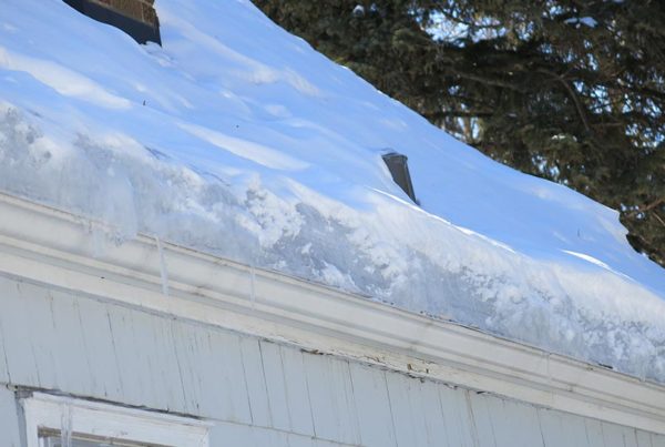 Close up of a home's roof line with ice dams.