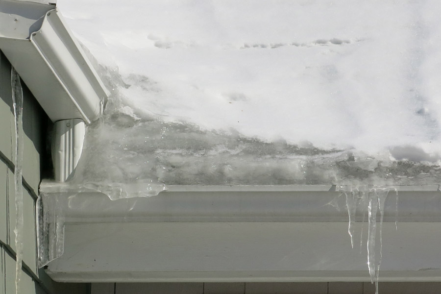 Close up of a home's roof line with ice dams.