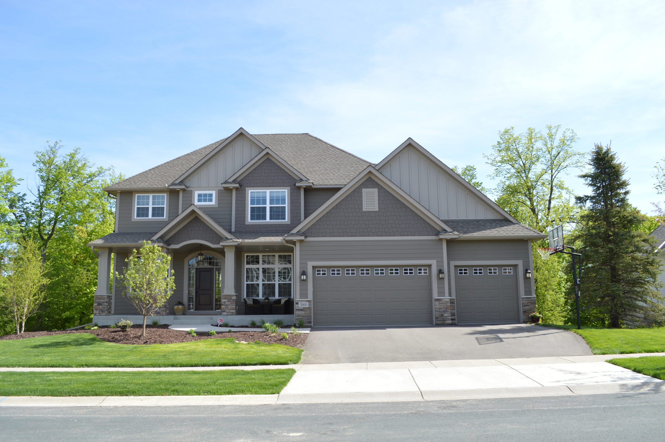 Get a free roofing inspection in Minnesota for a house with two garages and a driveway.