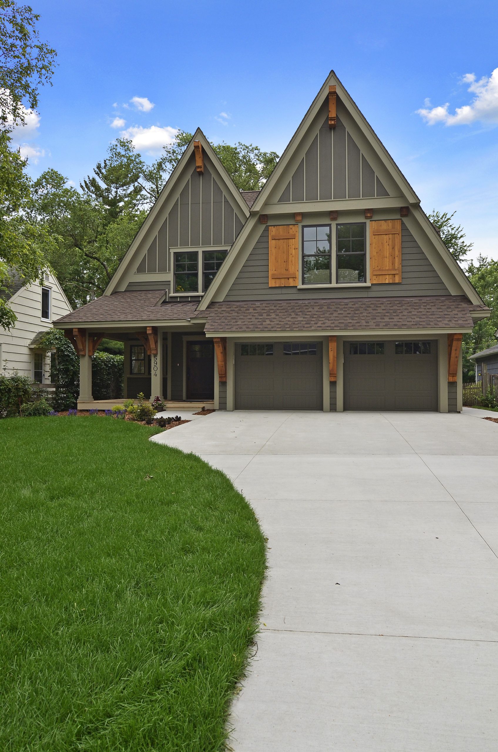 front view of a minnesota home with olive green siding and cedar shutters