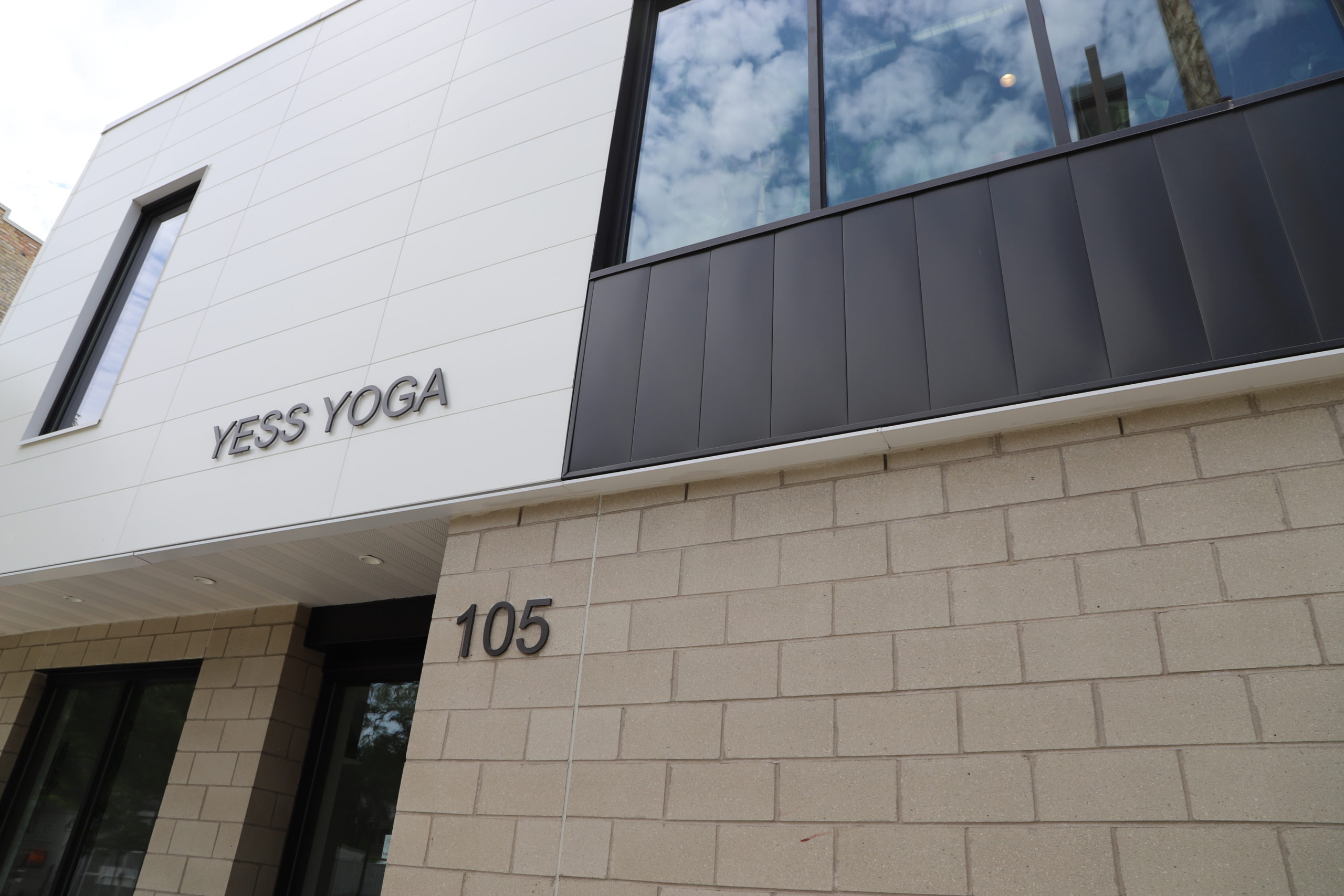 The corner of a two story building with a sign that says "Yess Yoga" on the side in Minneapolis, MN.