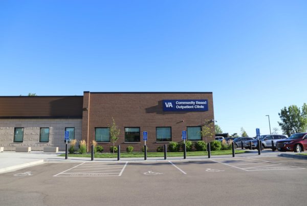 Large single story, brick and stone exterior building with sign in corner that says "VA Community Based Outpatient Clinic" in Shakopee, MN.