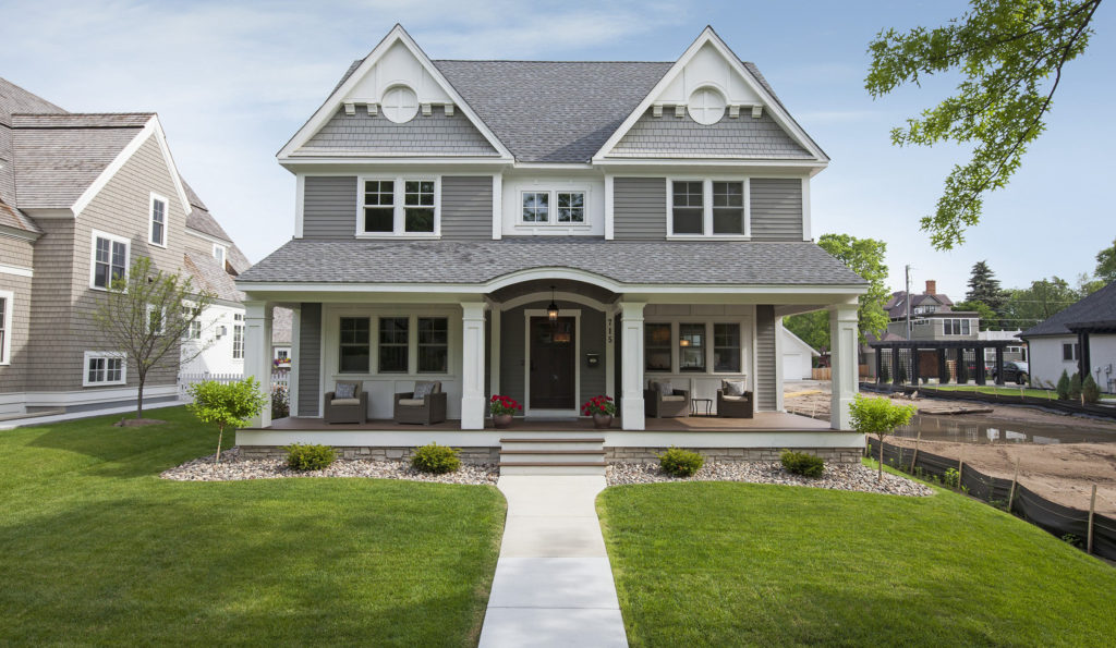 A gray house with a white front porch.