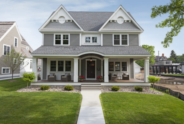 A gray house with a white front porch.