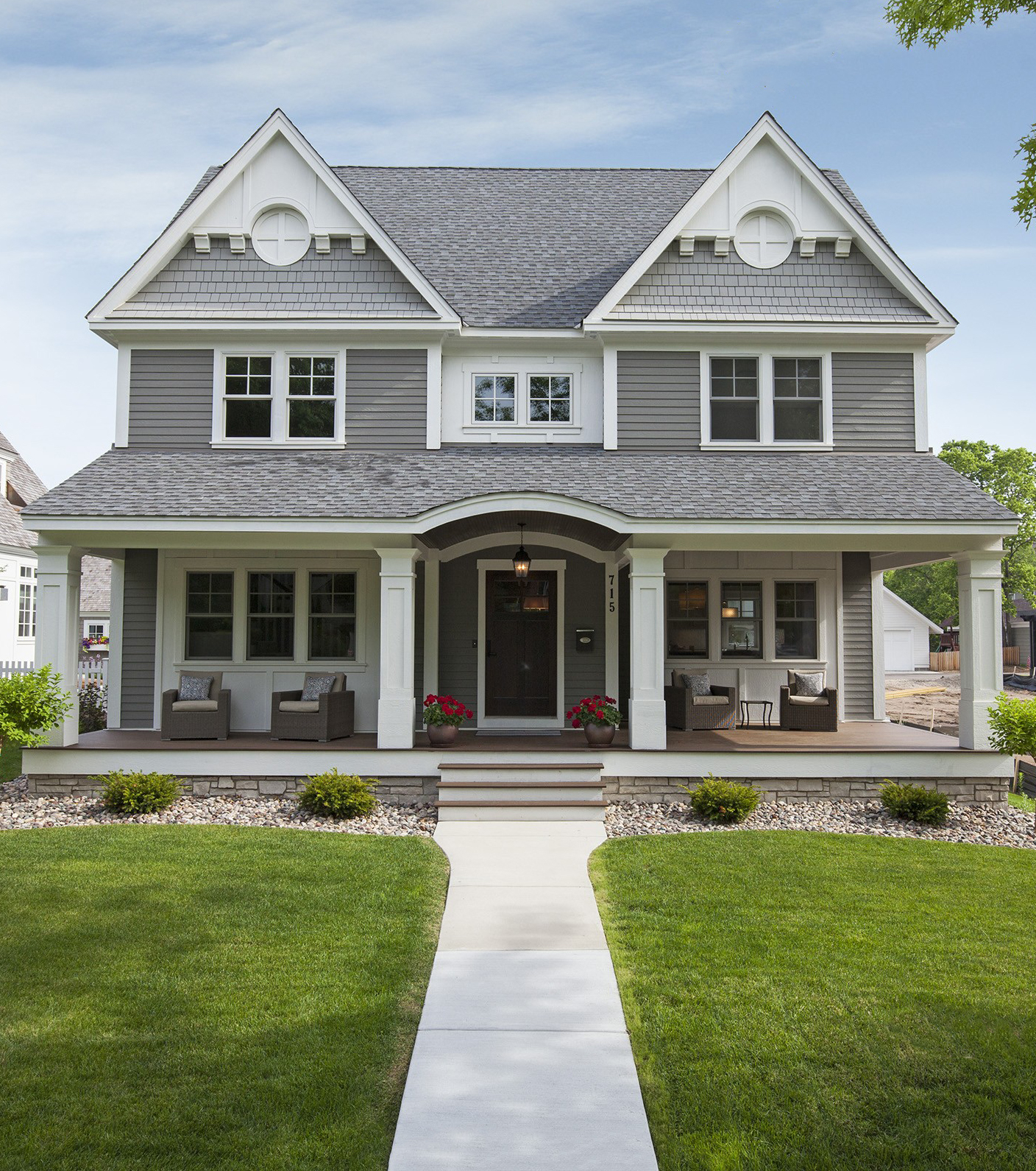 Enhance your home's curb appeal and value with a stylish white front porch and gray siding.