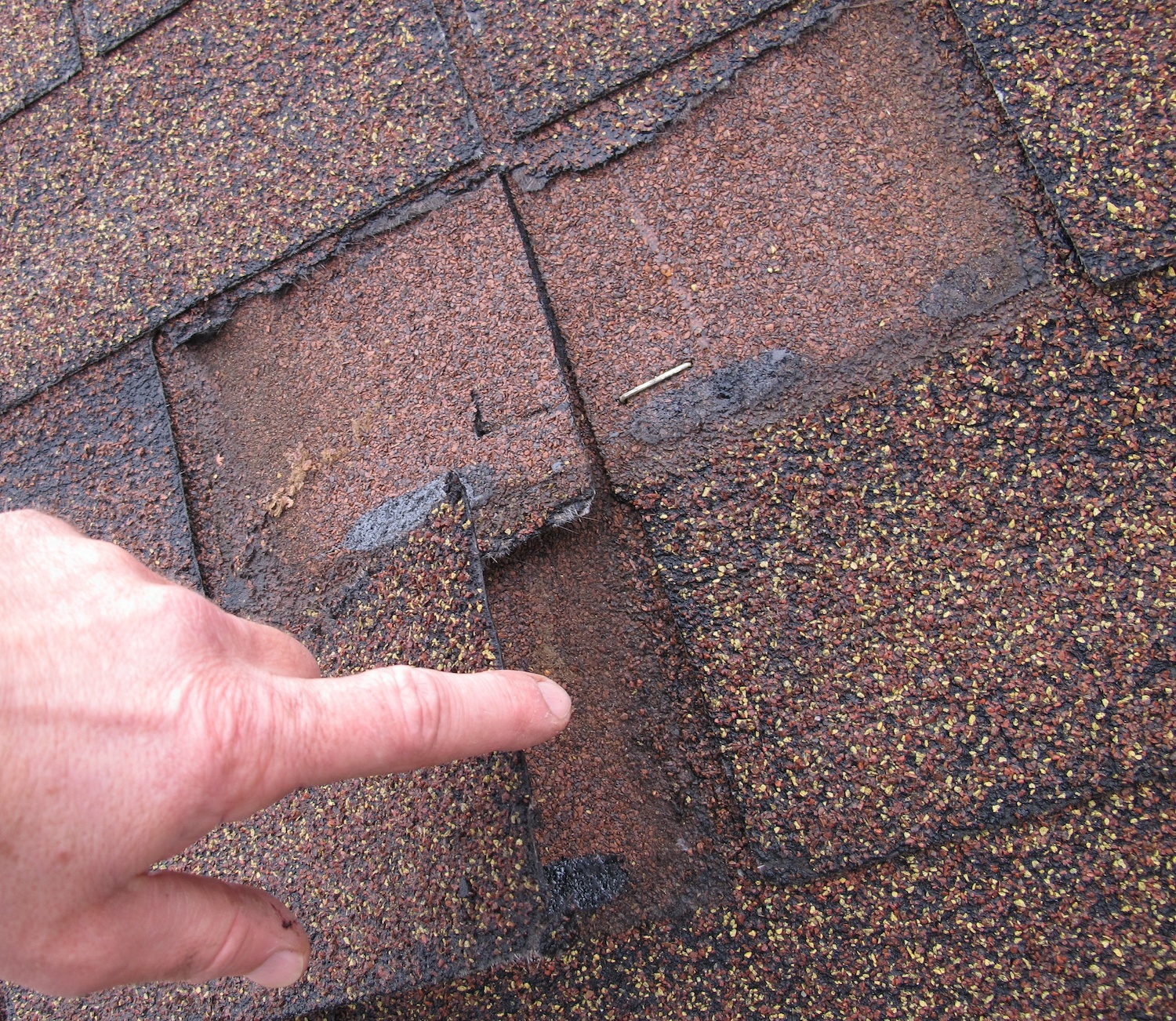 Shingle damage and missing shingles on a roof.