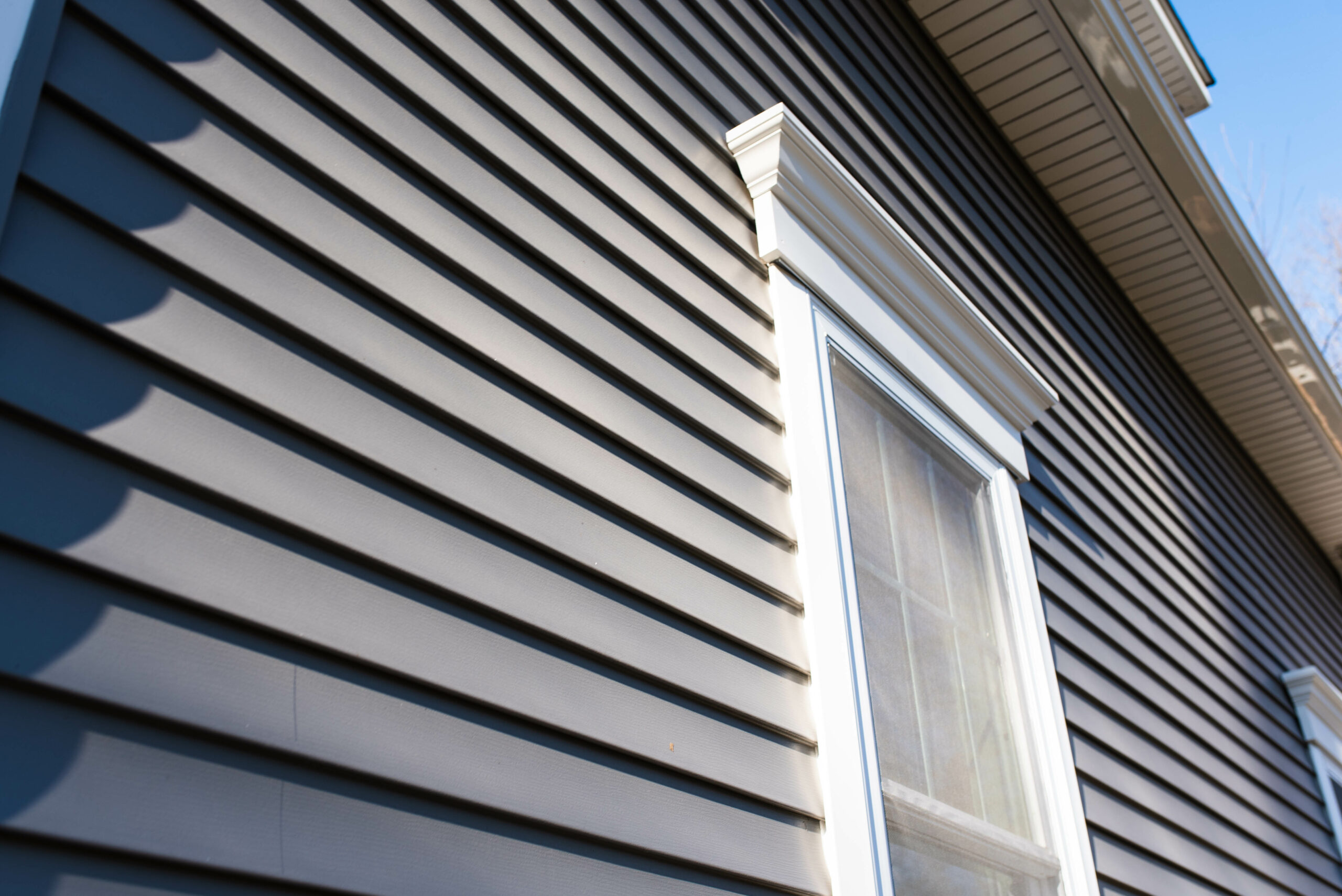 An ultimate home siding guide showcasing a house with vinyl siding and a window.
