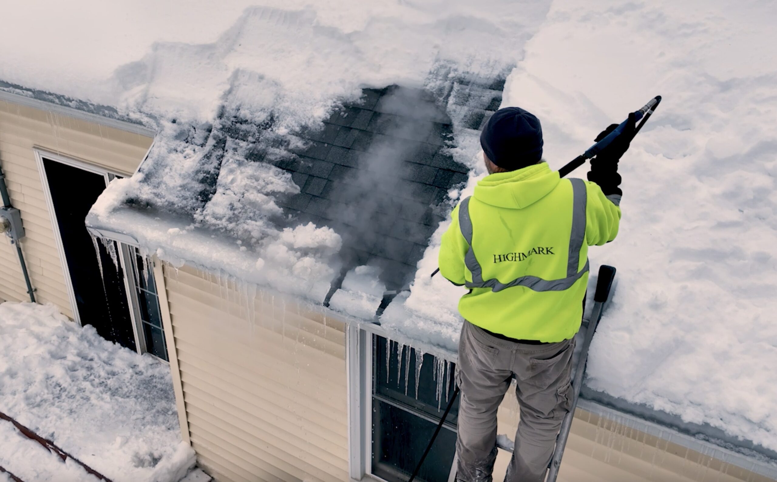 Highmark employee removes ice dam from a roof with steam removal method